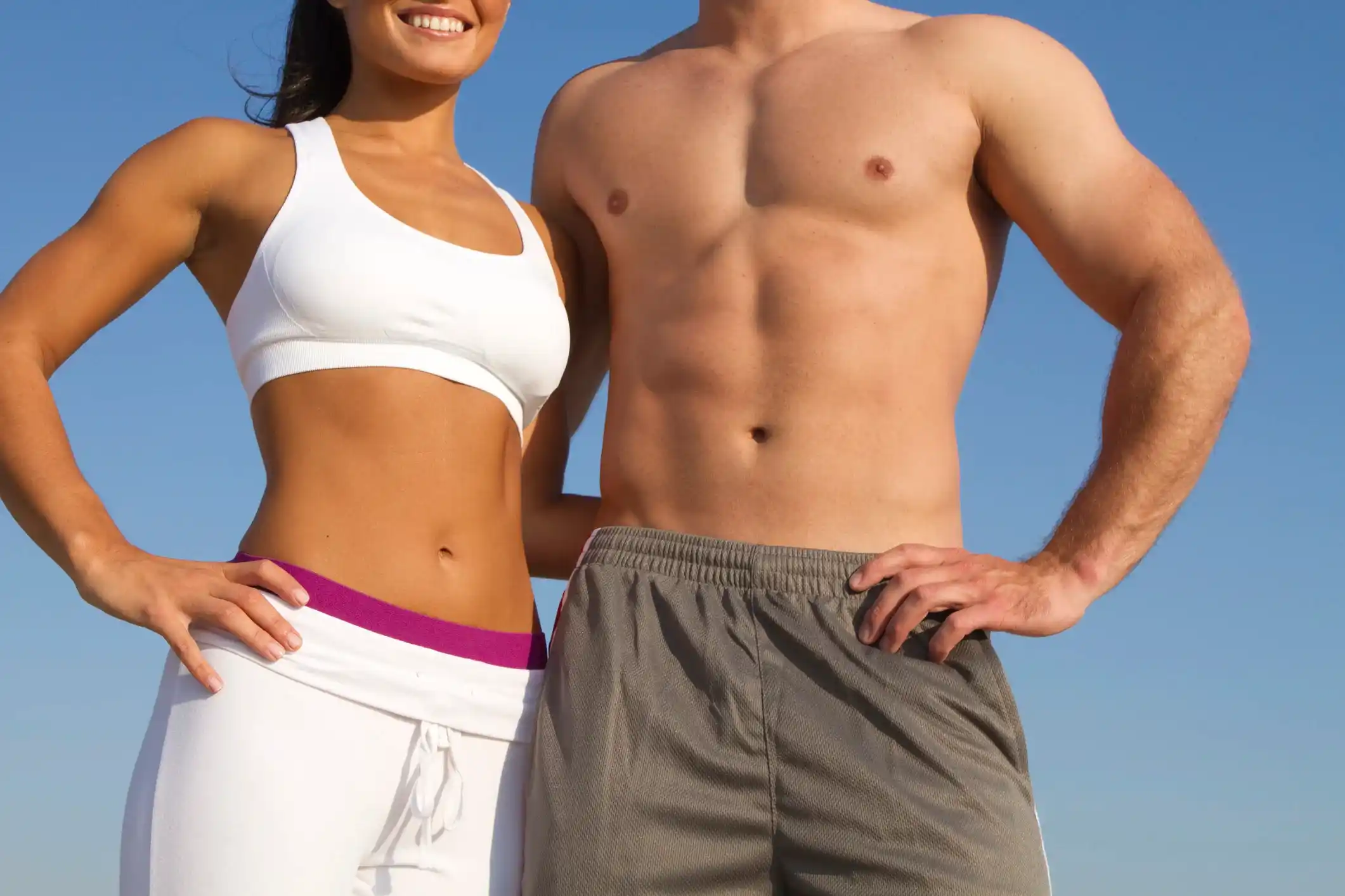 A man and woman in athletic wear stand together, showcasing fitness and well-being at Unfiltered Medical Spa.