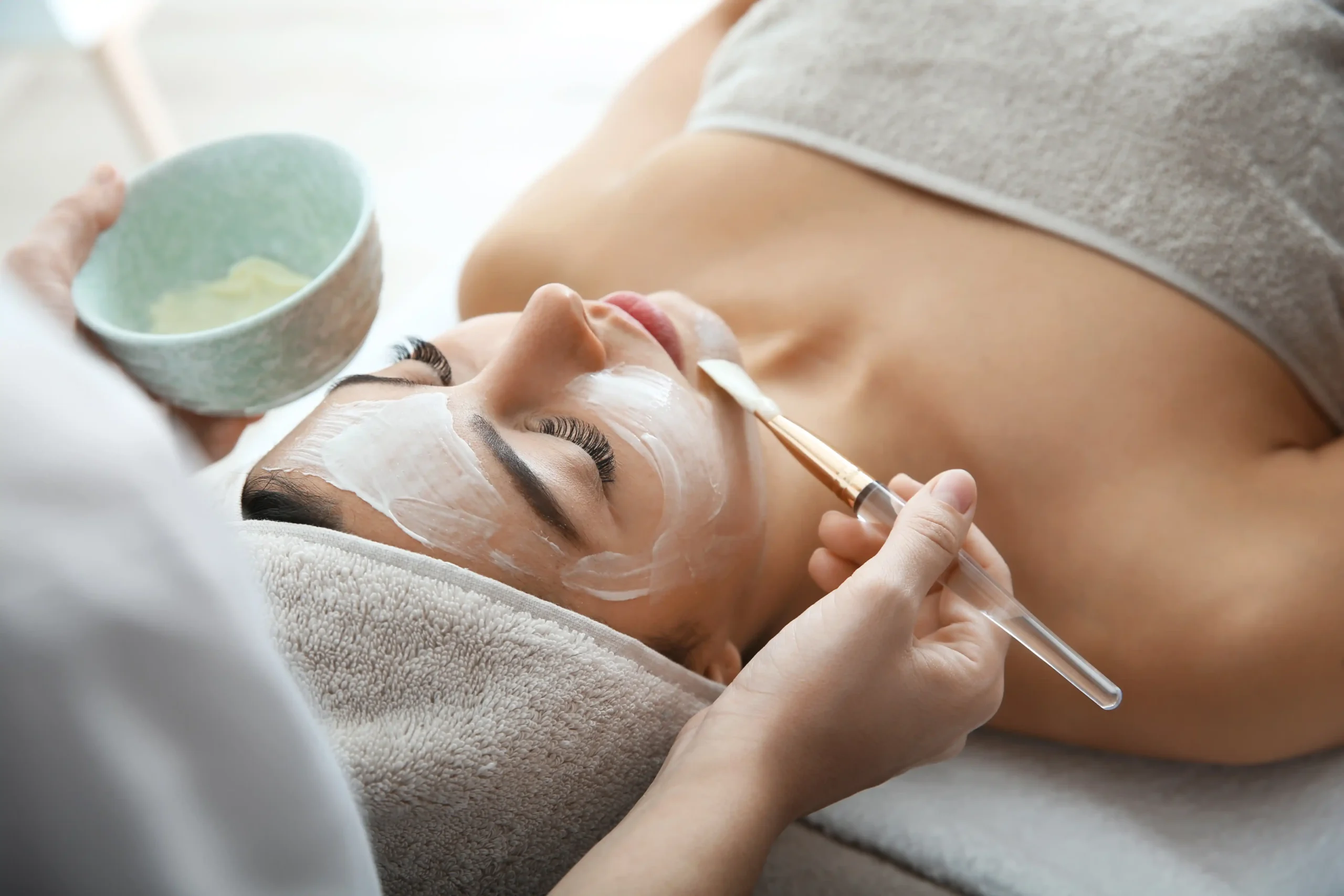 Woman receiving a professional facial mask application at Unfiltered Medical Spa in Lehi, UT — representing skincare treatments for the Skincare vs. Injectables service.